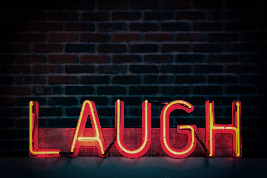 Red neon sign reading LAUGH on a brick wall